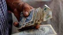 Un hombre sostiene un fajo de pesos cubanos. En Cuba circulan tre smonedas con cuatro tipos de cambio. (REUTERS/Desmond Boylan/Archivo)